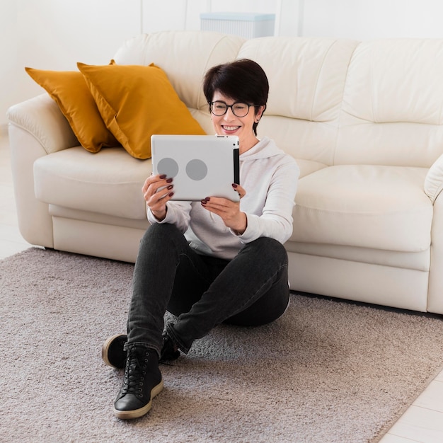 Vue de face de la femme à la maison avec tablette