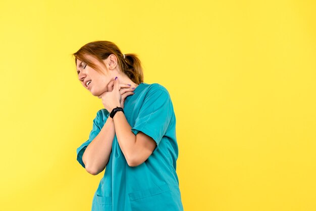 Vue de face femme médecin ayant des problèmes respiratoires sur l'espace jaune