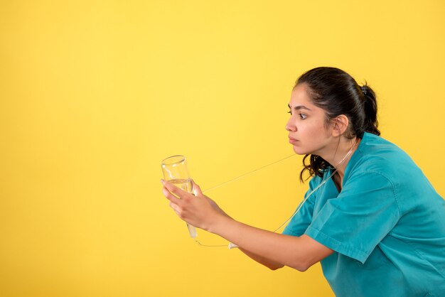 Vue de face femme médecin avec bouteille de sérum debout