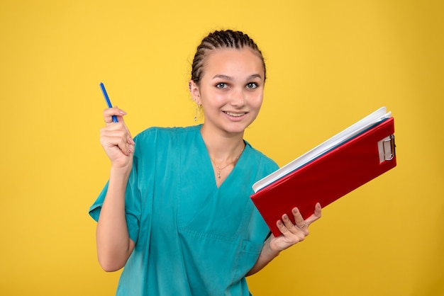 Vue de face femme médecin en chemise médicale avec différentes notes, infirmière hôpital émotion couleur santé covid-19 medic