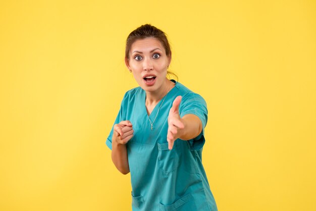 Vue de face femme médecin en chemise médicale sur fond jaune