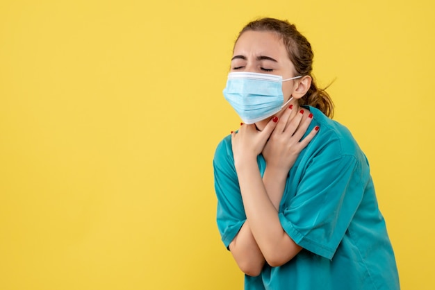 Vue de face femme médecin en chemise médicale et masque ayant mal à la gorge, virus de la santé pandémique covid-19 uniforme de couleur