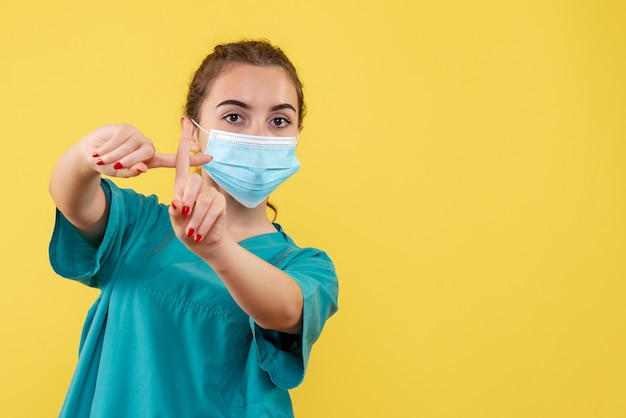 Vue de face femme médecin en chemise médicale et masque, coronavirus uniforme du virus pandémique de la couleur de la santé
