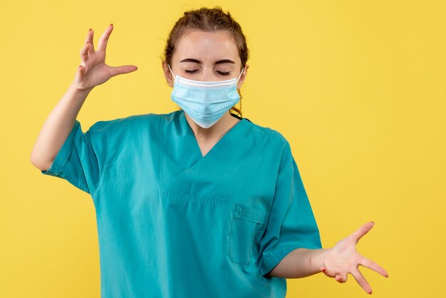 Vue de face femme médecin en chemise médicale et masque, couleur de la santé du virus, uniforme de la pandémie de covid-19