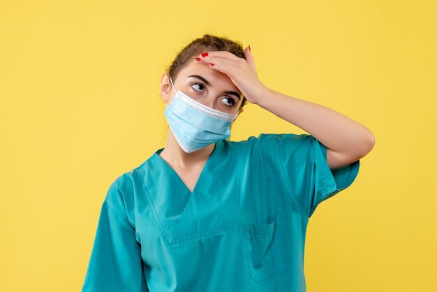 Vue de face femme médecin en chemise médicale et masque, pandémie de covid de couleur de santé de virus uniforme