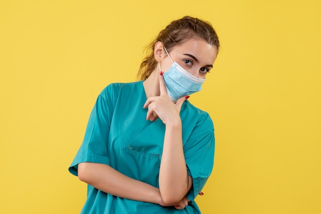 Vue de face femme médecin en chemise médicale et masque, pandémie de covid couleur santé virus