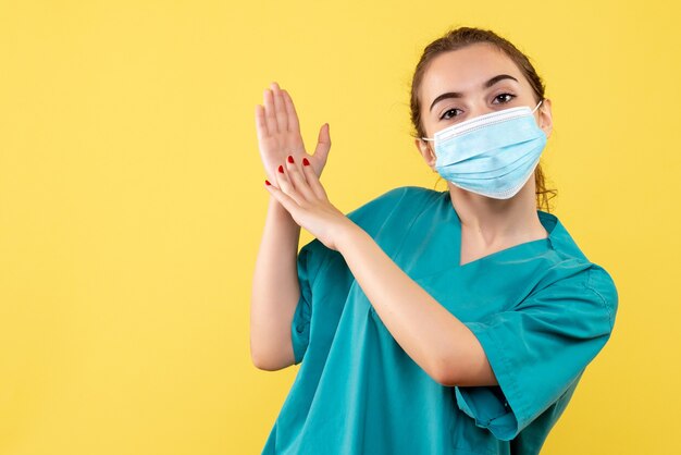 Vue de face femme médecin en chemise médicale et masque stérile, virus pandémique de la santé des couleurs covid-19