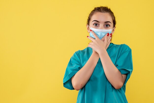 Vue de face femme médecin en chemise médicale et masque, virus de la santé du coronavirus uniforme covid-19