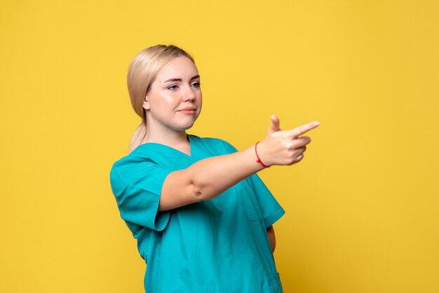 Vue de face femme médecin en chemise médicale pointant, infirmière covid pandémie émotion infirmière