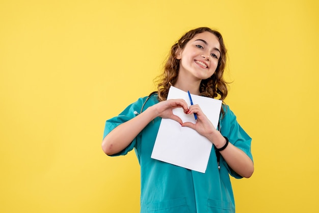 Vue De Face Femme Médecin En Chemise Médicale Tenant L'analyse Sur L'uniforme De Bureau Jaune Virus Pandémique De L'émotion De La Santé Covid-19