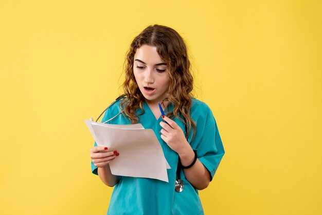 Vue de face femme médecin en chemise médicale tenant l'analyse, virus pandémique d'émotions de santé covid-19 uniforme