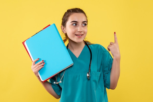 Vue de face femme médecin en chemise médicale tenant différentes notes, couleur virus émotion uniforme de la pandémie covid-19