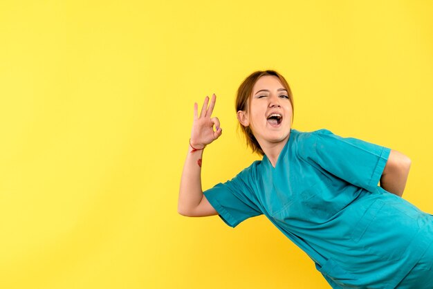 Vue de face femme médecin un clin de œil sur l'espace jaune