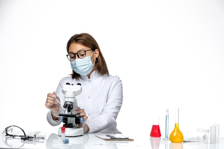 Photo gratuit vue de face femme médecin en costume médical blanc avec masque en raison de covid travaillant sur l'espace blanc