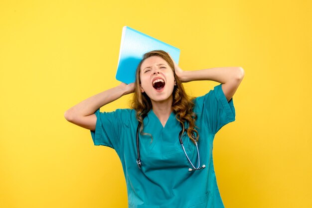 Photo gratuite vue de face de la femme médecin criant sur le mur jaune