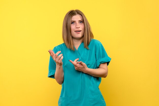 Vue de face femme médecin sur espace jaune