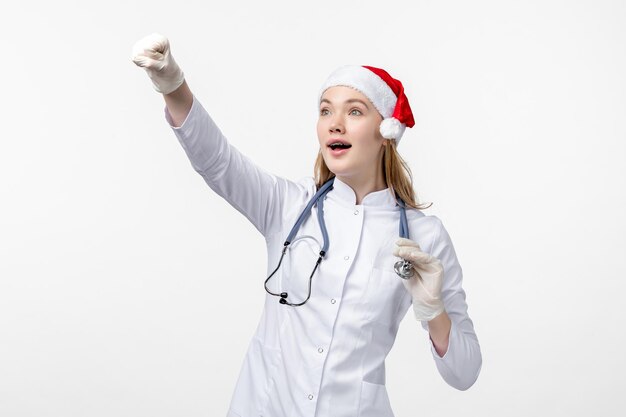 Vue de face d'une femme médecin excitée sur un mur blanc