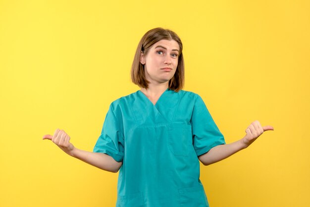 Vue de face femme médecin avec expression ennuyée sur l'espace jaune