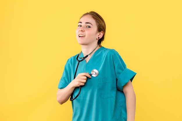 Vue de face femme médecin sur fond jaune médical émotion santé de l'hôpital