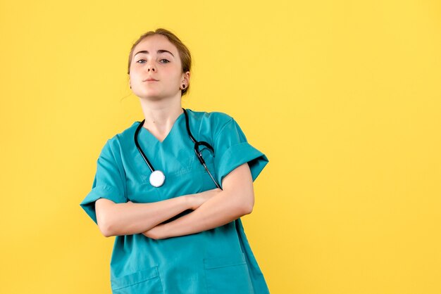 Vue de face femme médecin sur fond jaune santé des émotions de l'hôpital médical