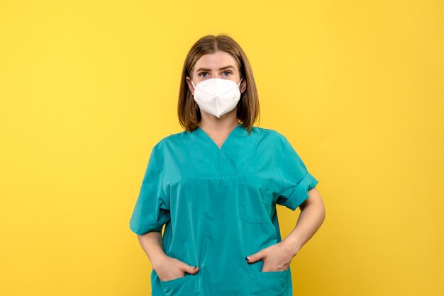 Photo gratuite vue de face femme médecin juste debout sur l'espace jaune