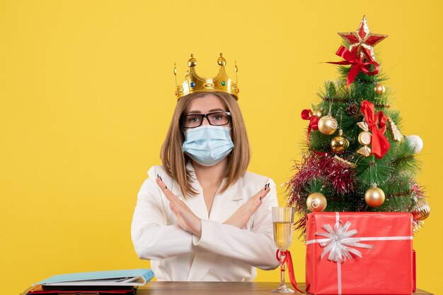 Vue de face femme médecin en masque stérile avec couronne