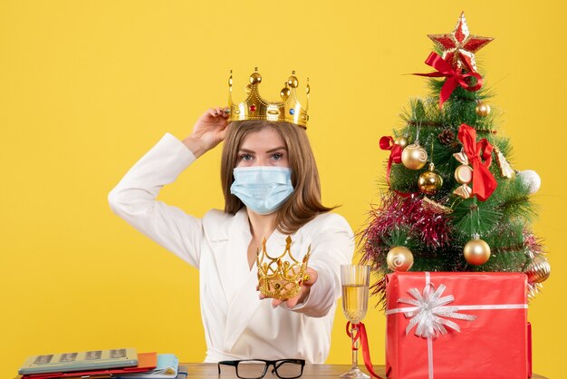 Vue de face femme médecin en masque stérile avec couronne