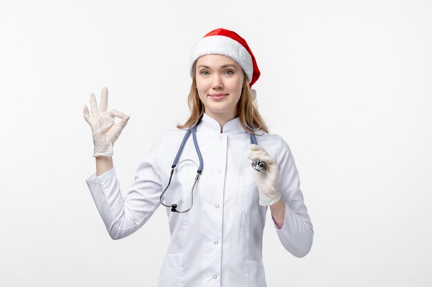 Vue de face d'une femme médecin sur un mur blanc