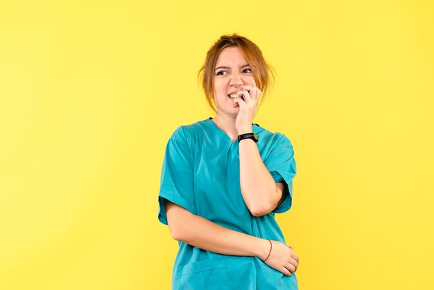 Vue de face femme médecin nerveux sur l'espace jaune