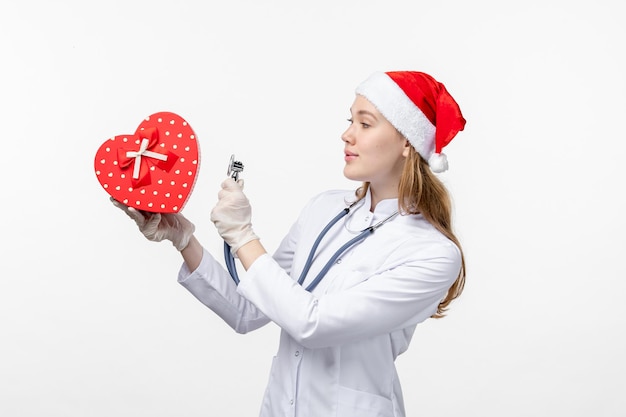 Vue de face d'une femme médecin observant des vacances présentes sur un mur blanc