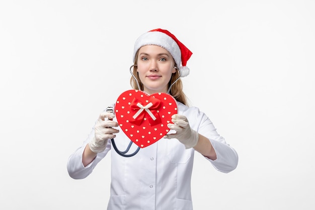 Vue de face d'une femme médecin observant des vacances présentes sur un mur blanc