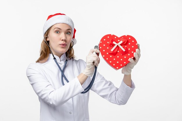 Vue de face d'une femme médecin observant des vacances présentes sur un mur blanc