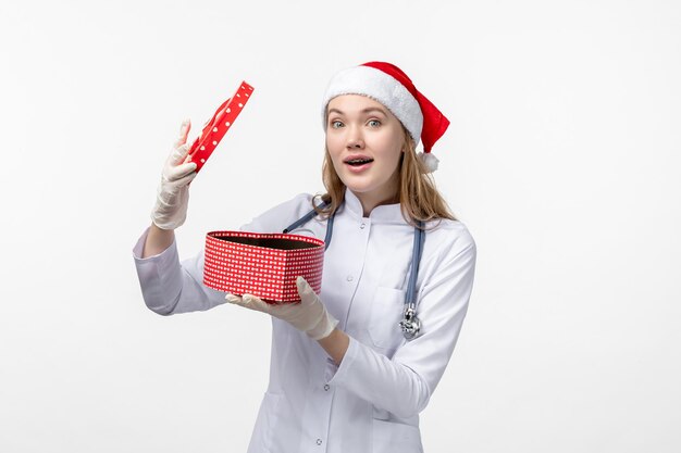 Vue de face d'une femme médecin ouverture de vacances présente sur mur blanc