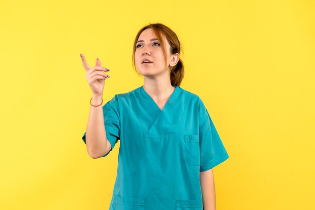 Vue de face femme médecin pensant juste à un espace jaune