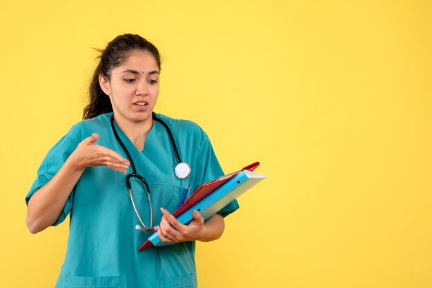 Vue de face femme médecin pointant sur les dossiers