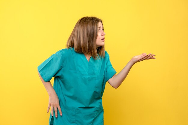 Vue de face femme médecin posant sur l'espace jaune