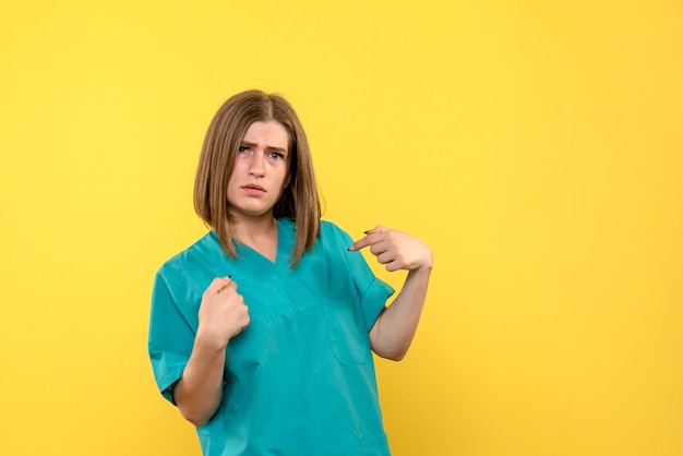 Vue de face femme médecin posant sur l'espace jaune