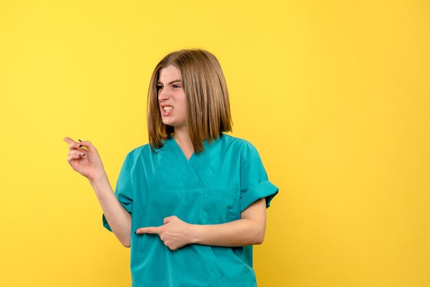 Vue de face femme médecin posant sur l'espace jaune