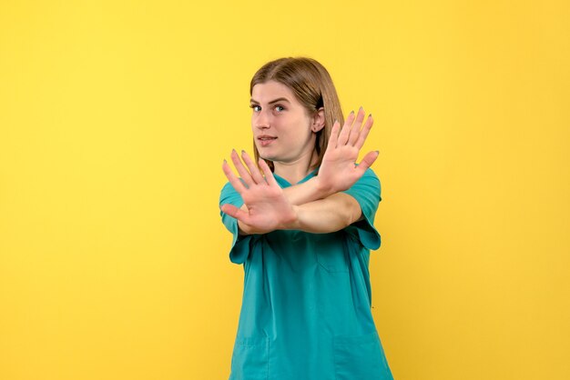 Vue de face femme médecin posant sur l'espace jaune