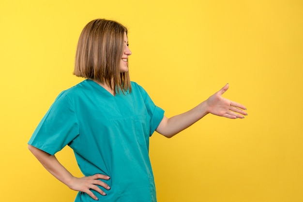 Vue de face femme médecin posant sur l'espace jaune