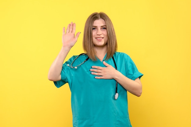 Vue de face femme médecin posant sur l'espace jaune