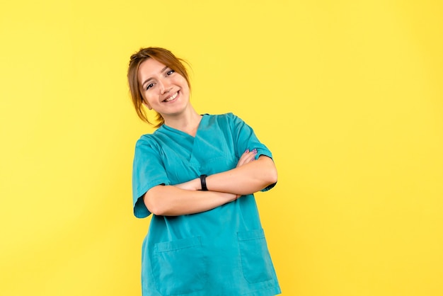 Vue de face femme médecin souriant sur l'espace jaune