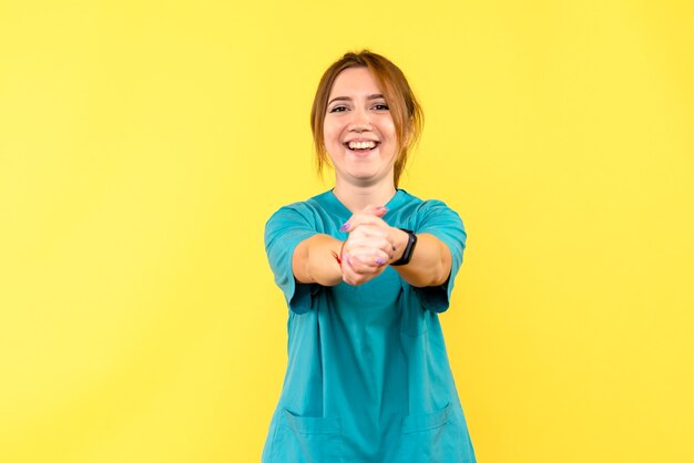 Vue de face femme médecin souriant sur l'espace jaune