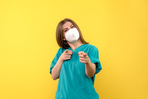 Vue de face femme médecin souriant sur l'espace jaune