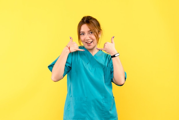 Photo gratuite vue de face femme médecin souriant sur l'espace jaune