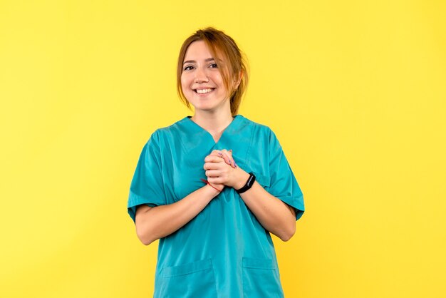 Vue de face femme médecin souriant sur l'espace jaune