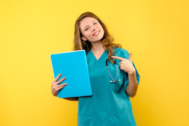 Vue de face femme médecin souriant sur l'espace jaune