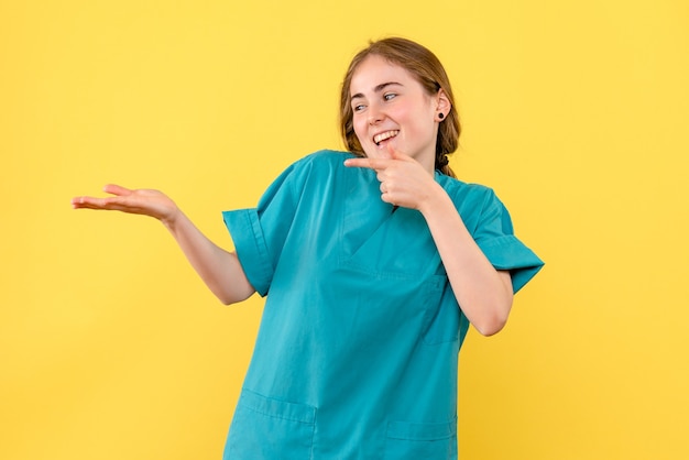 Vue De Face Femme Médecin Souriant Sur Fond Jaune émotion Hôpital Médical Santé