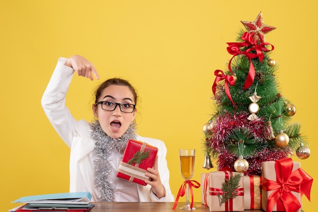 Vue de face femme médecin tenant le cadeau de Noël