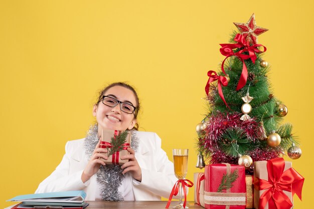 Vue de face femme médecin tenant le cadeau de Noël